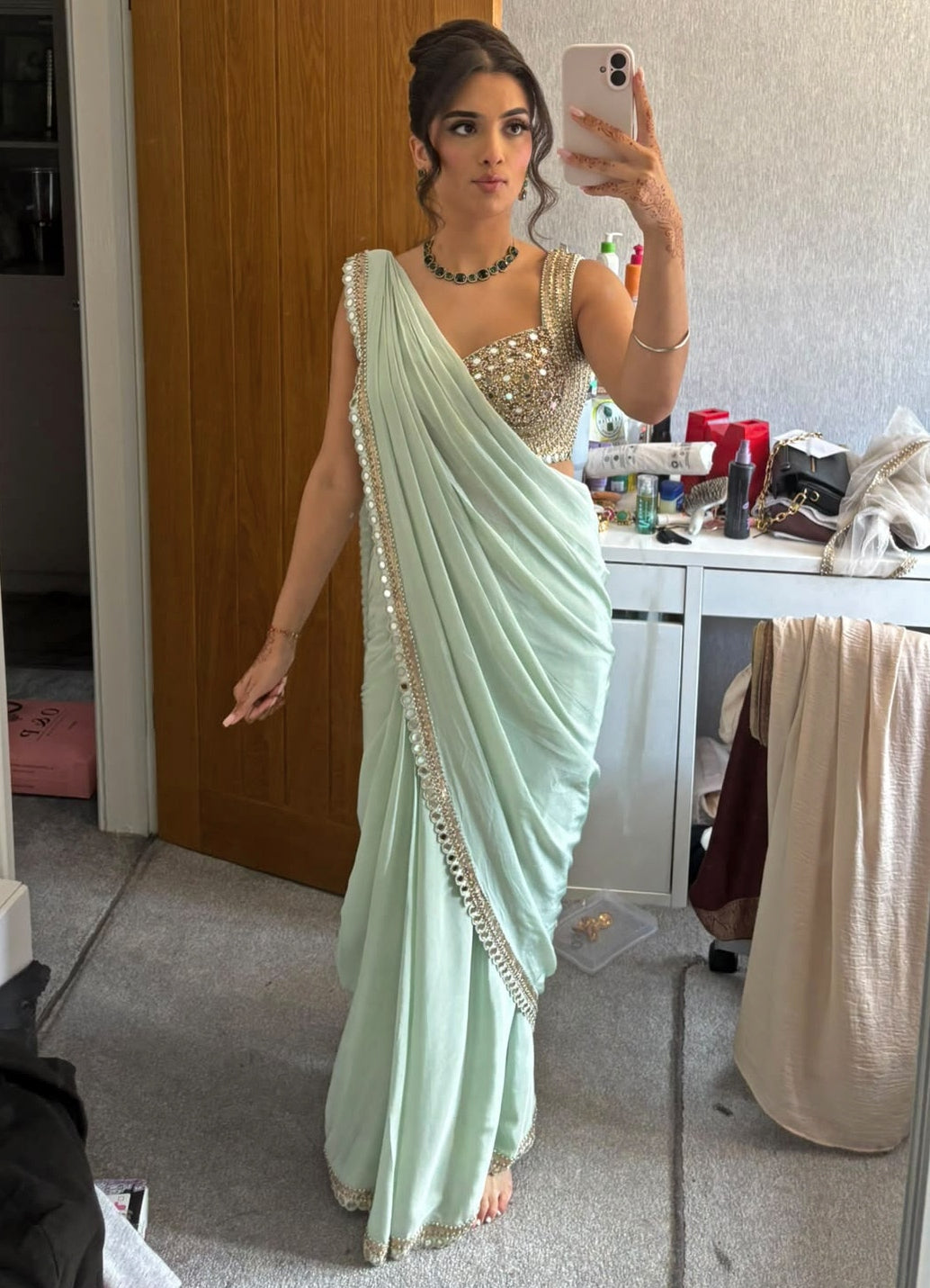 Amba wearing a dusty green crepe pre-draped saree by Nidhika Shekhar with an embellished blouse for her brother's wedding in the UK