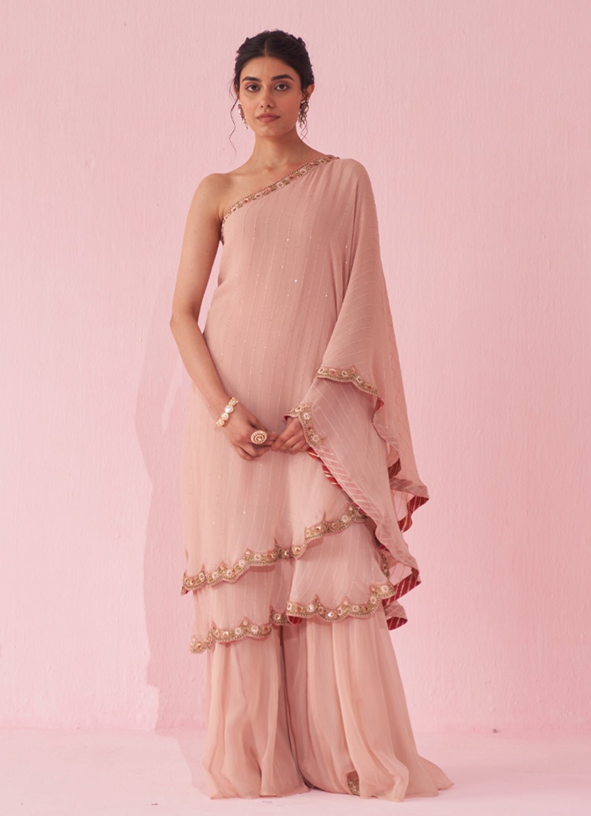 Blush pink one-shoulder kurta sharara set by Studio Bagechaa — modern pink sharara set for UK wedding guests
