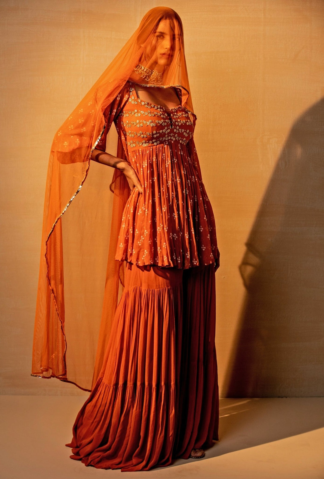 Rust orange printed georgette kurta sharara set by Esha Koul for wedding guest