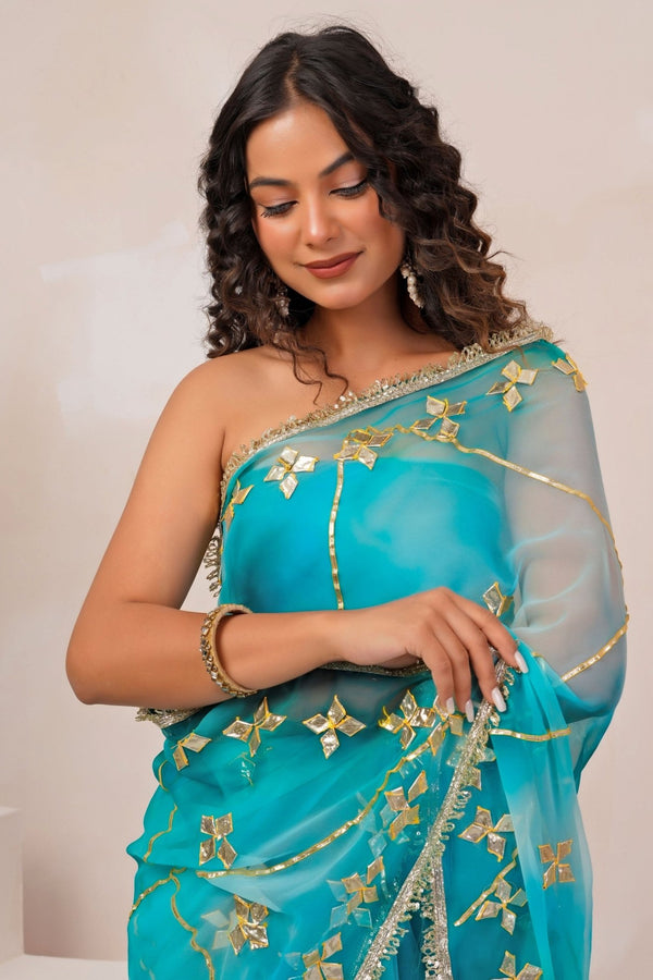 Turquoise blue shaded georgette saree for a formal family celebration